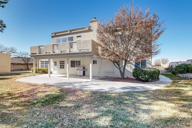 back of property with a patio and a yard