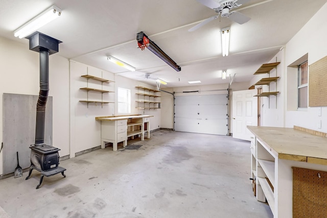 garage featuring a workshop area, ceiling fan, and a wood stove