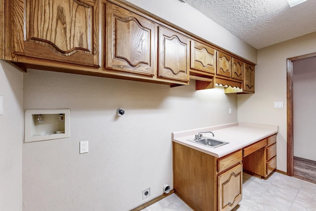 clothes washing area featuring sink, electric dryer hookup, cabinets, washer hookup, and a textured ceiling