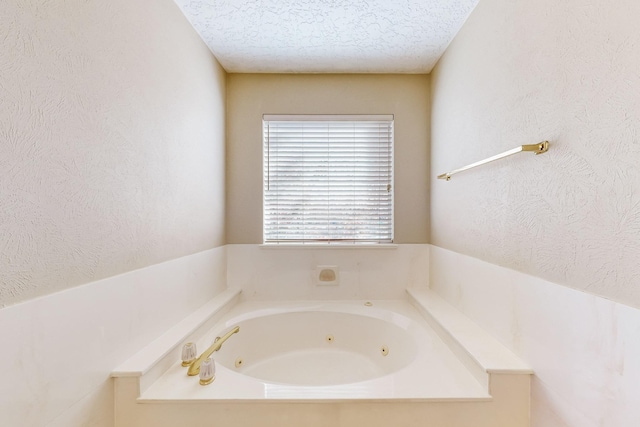 bathroom with a textured ceiling and a washtub