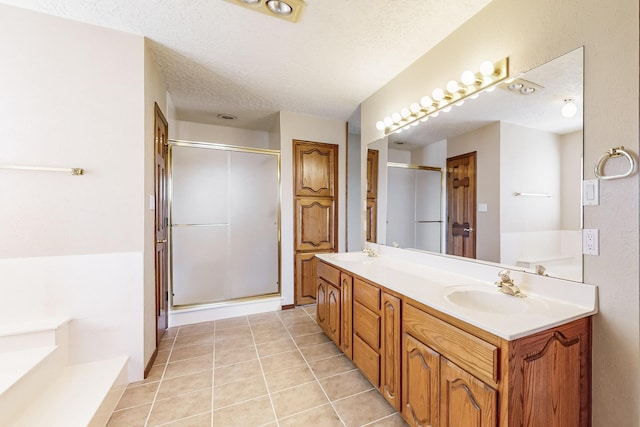 bathroom with vanity, tile patterned floors, plus walk in shower, and a textured ceiling