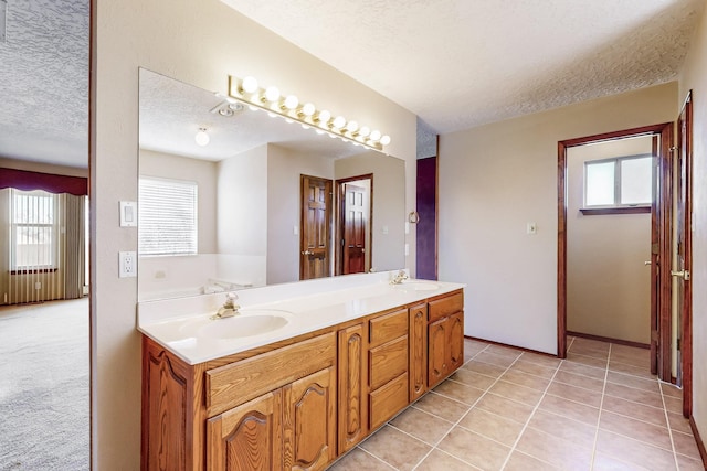 bathroom featuring tile patterned floors, vanity, and a textured ceiling