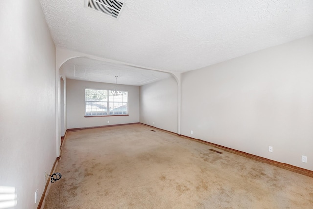 carpeted spare room with a textured ceiling