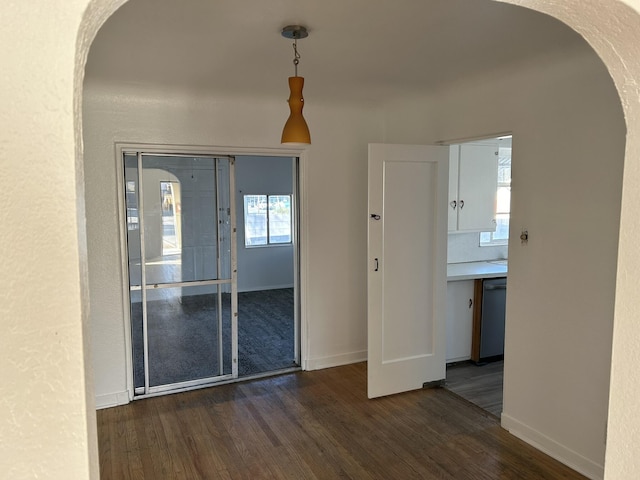 spare room featuring a wealth of natural light and dark wood-type flooring