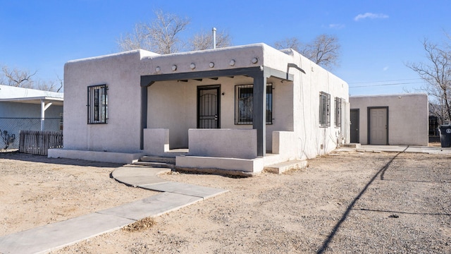 pueblo revival-style home featuring a porch