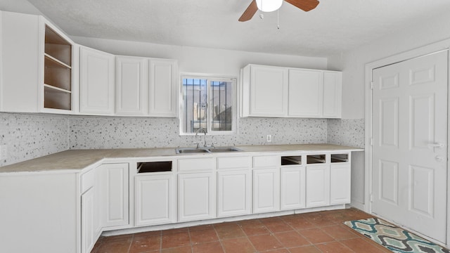 kitchen featuring dark tile patterned flooring, white cabinetry, sink, and a textured ceiling