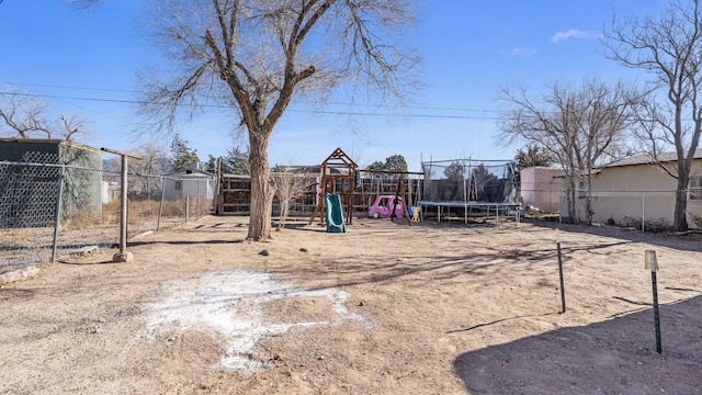 view of yard with a trampoline and a playground