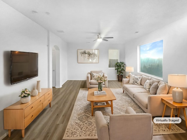 living room with ceiling fan and dark hardwood / wood-style flooring