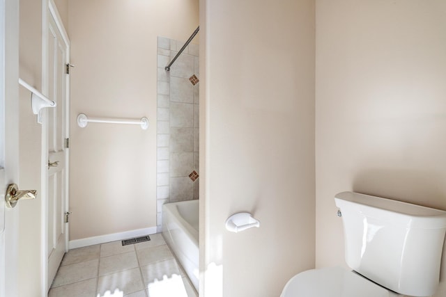 bathroom featuring tile patterned floors, tiled shower / bath combo, and toilet