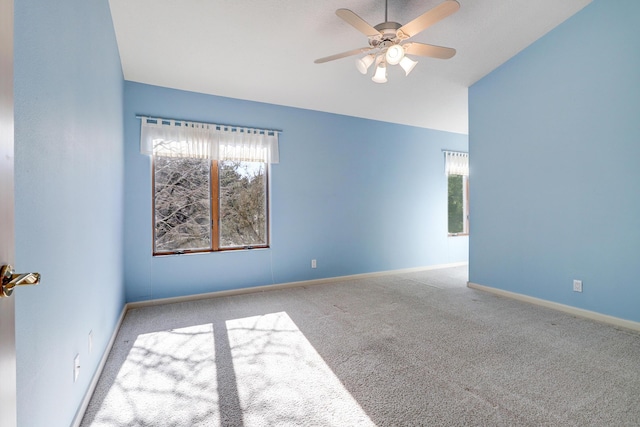 spare room featuring ceiling fan, light colored carpet, and lofted ceiling