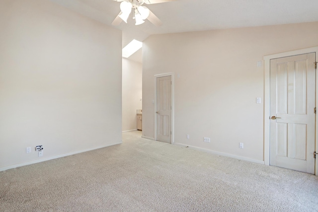 empty room with light colored carpet, vaulted ceiling, and ceiling fan