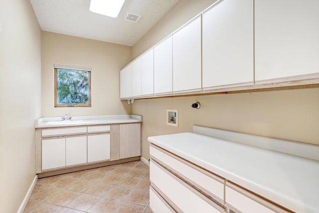 clothes washing area with sink, cabinets, and washer hookup