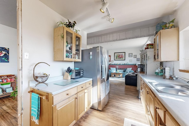 6284 State Highway 55, Mountainair, NM 87036 - kitchen featuring light wood-style floors, stainless steel fridge with ice dispenser, light countertops, open floor plan, and glass insert cabinets