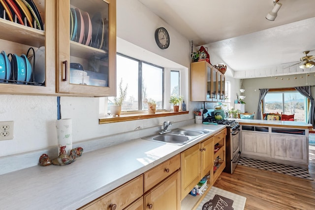 kitchen featuring ceiling fan, stainless steel gas stove, light brown cabinets, sink, and light hardwood / wood-style floors