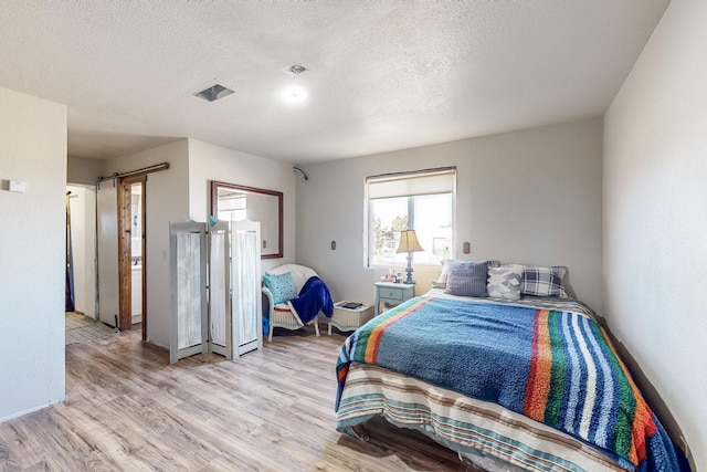 6284 State Highway 55, Mountainair, NM 87036 - bedroom with light wood finished floors and a textured ceiling