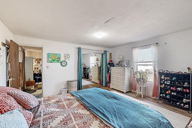 6284 State Highway 55, Mountainair, NM 87036 - bedroom with wood finished floors and a textured ceiling