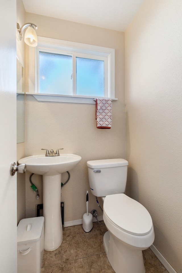 bathroom featuring tile patterned floors, plenty of natural light, and toilet