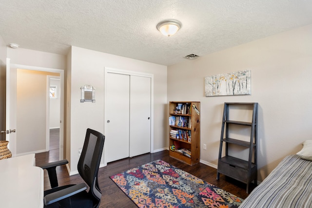 home office featuring a textured ceiling and dark hardwood / wood-style floors