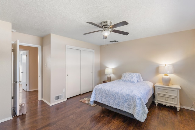 bedroom with dark hardwood / wood-style floors, ceiling fan, a textured ceiling, and a closet