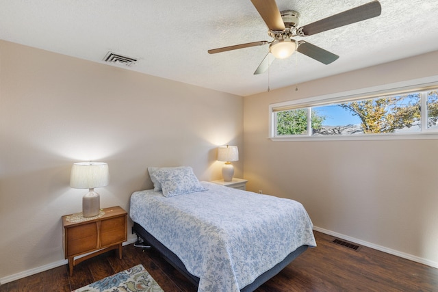 bedroom featuring a textured ceiling, ceiling fan, and dark hardwood / wood-style floors