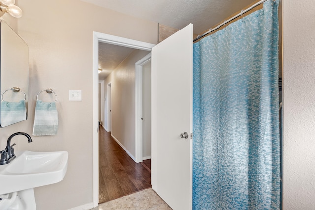 bathroom with sink, wood-type flooring, a textured ceiling, and a shower with shower curtain