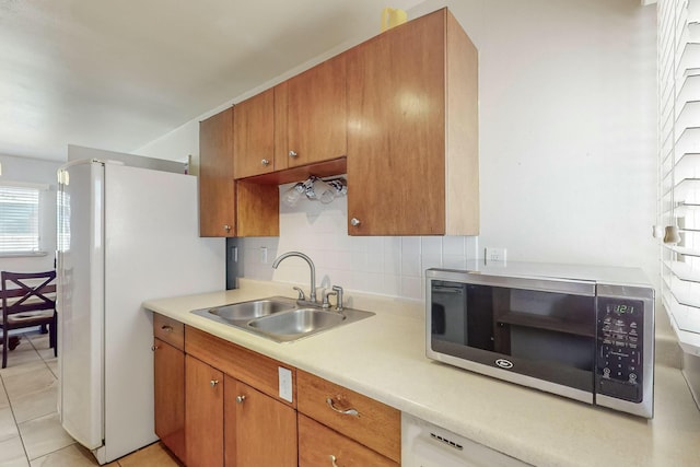 kitchen with decorative backsplash, white refrigerator, light tile patterned flooring, and sink