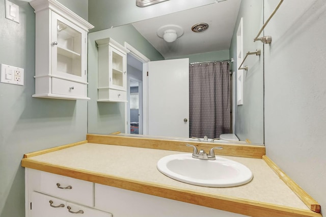 bathroom with toilet, vanity, and walk in shower