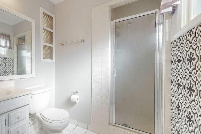 bathroom featuring tile patterned flooring, vanity, a shower with door, and toilet