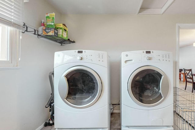 clothes washing area with washer and clothes dryer and light tile patterned flooring