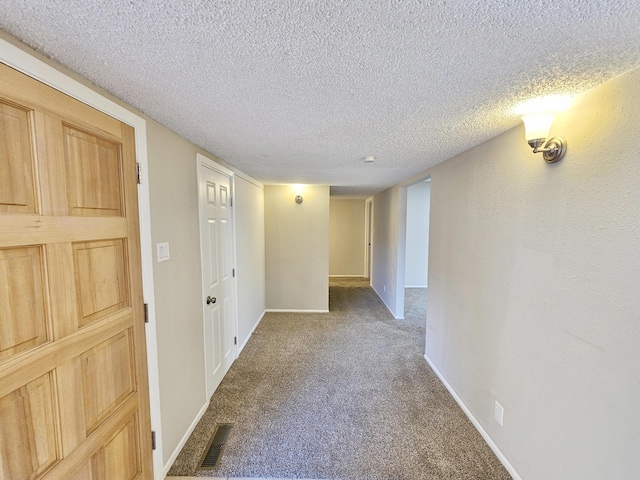 unfurnished room featuring carpet flooring and a textured ceiling