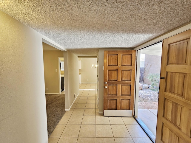 foyer entrance featuring light tile patterned floors and a textured ceiling