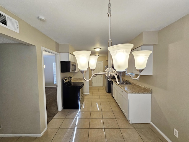 kitchen featuring light stone counters, black range with electric cooktop, sink, light tile patterned floors, and white cabinets