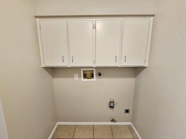 clothes washing area featuring cabinets, electric dryer hookup, hookup for a gas dryer, hookup for a washing machine, and light tile patterned floors