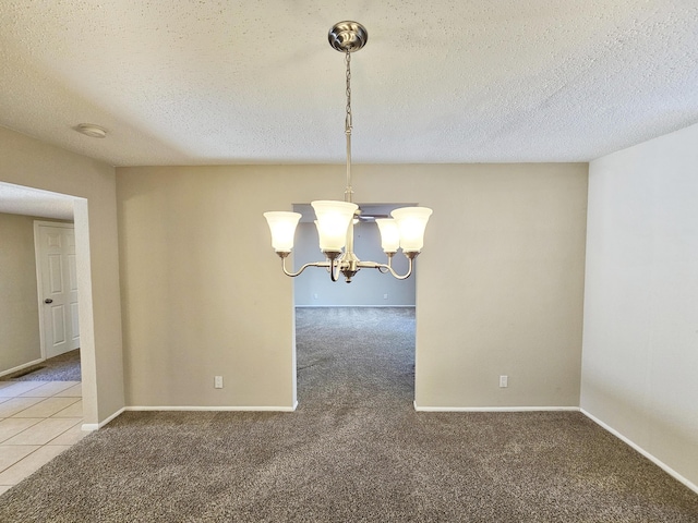 unfurnished dining area featuring carpet flooring, a textured ceiling, and a chandelier