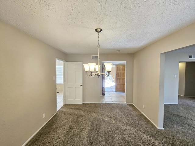 unfurnished dining area featuring light carpet, a textured ceiling, and a notable chandelier