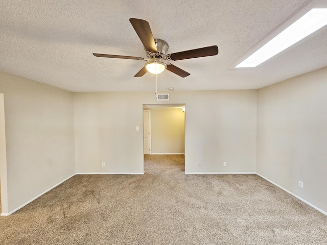 empty room featuring carpet, a textured ceiling, and ceiling fan