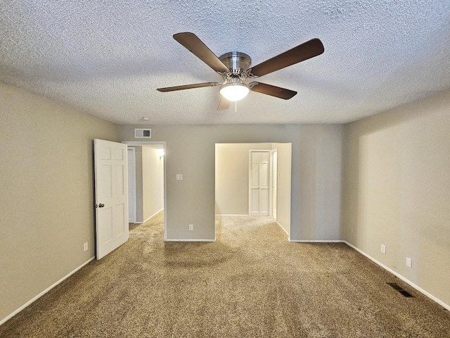 carpeted empty room featuring a textured ceiling and ceiling fan