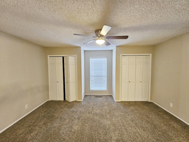 unfurnished bedroom featuring multiple closets, ceiling fan, carpet floors, and a textured ceiling