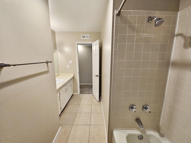 bathroom with tile patterned flooring, vanity, and tiled shower / bath combo