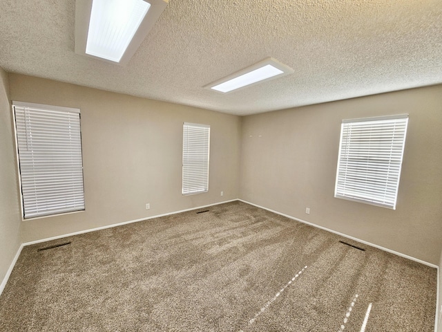 unfurnished room featuring carpet and a textured ceiling