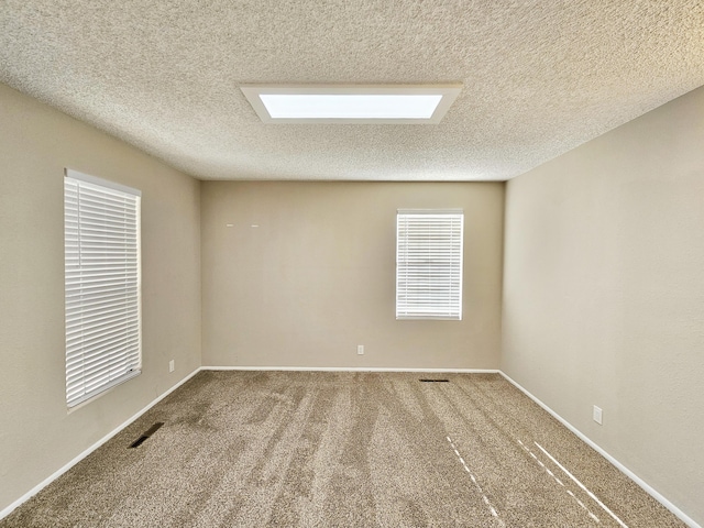 carpeted empty room with a textured ceiling