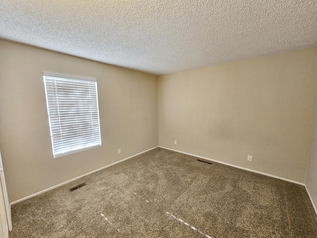 empty room with carpet and a textured ceiling