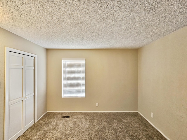 unfurnished bedroom with carpet, a textured ceiling, and a closet