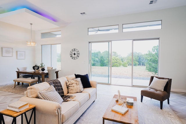 living room with a towering ceiling and light parquet flooring