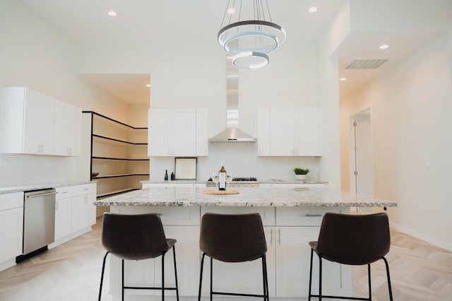 kitchen with white cabinets, light parquet floors, a kitchen island, and dishwasher