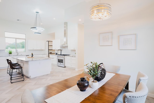 dining area featuring sink and light parquet flooring