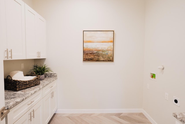 laundry room featuring hookup for an electric dryer, hookup for a washing machine, light parquet flooring, and cabinets