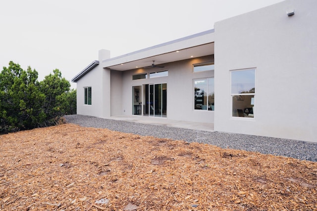 back of property featuring ceiling fan and a patio