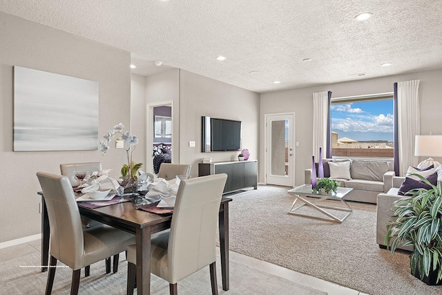 carpeted dining space featuring a textured ceiling