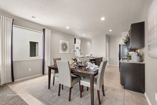 tiled dining room with sink and a textured ceiling